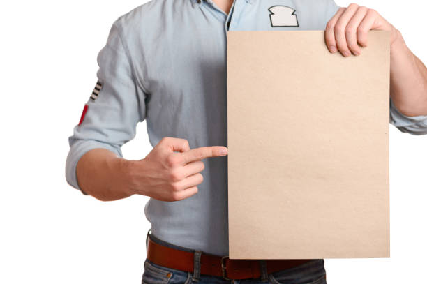 istock Stylish man in a light denim shirt indicates a blank sheet which holds a 1136358071