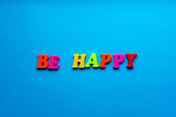 text be happy from plastic magnetic letters on blue background