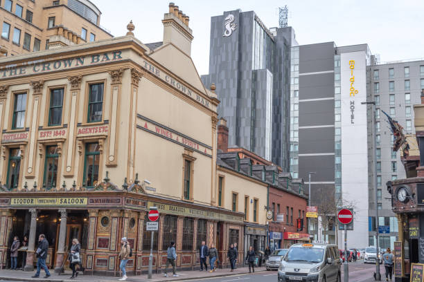Belfast, United Kingdom - March 15, 2019:  three famous landmarks in Belfast city centre, i.e. The Crown Bar (a Victorian pub, dating from 1849), the Grand Central Hotel (5 star) and the Maldon Hotel (3 star).  Both hotels were opened in 2018, in response to the growing demand for overnight accommodation in Belfast and the development of the tourism as an important element of the region's economy since the Good Friday Agreement (1998).