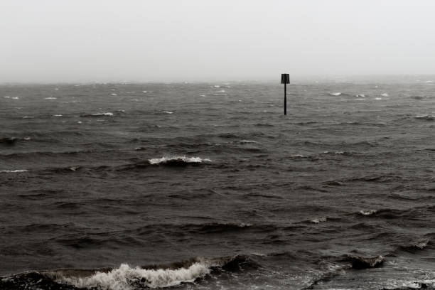 Stormy sea on Belfast Lough, low tide marker, and sea mist of advancing storm.  County Down,Northern Ireland.  Toned image.