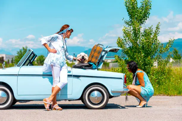 Photo of Mature Couple on a Road trip Fixing a Broken Vintage car