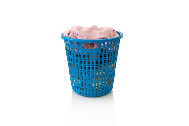 istock Clothes in a laundry wooden basket on white background 1136367831