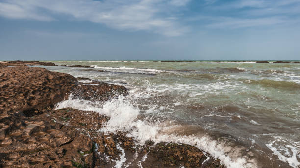 istock Splash of waves on a rocky seashore 1136370313