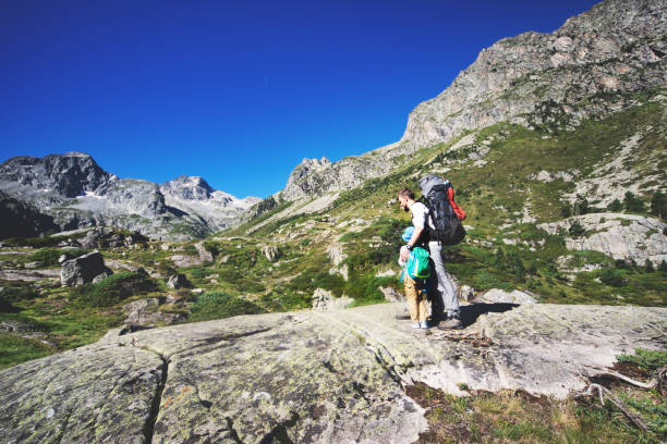 istock Father and son hiking together in mountains 1136370942