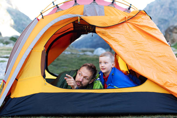 Last glow of daylight hits the mountain peaks. The warm and illuminated tent promises a comfortable night.