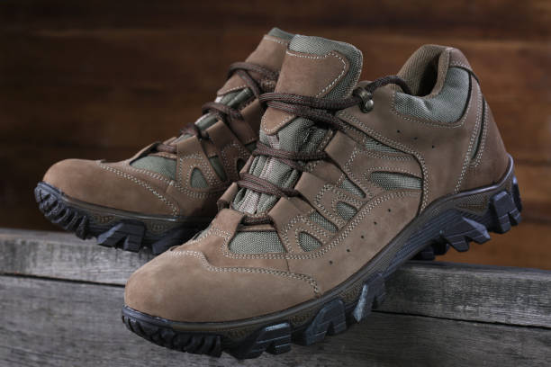 istock Hiking boots on wooden background. Closeup 1136372740