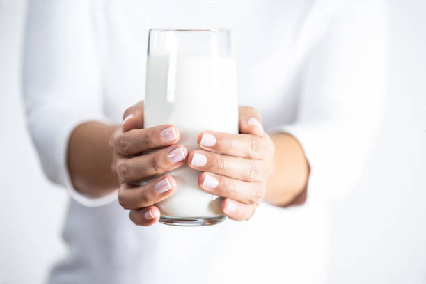 Unrecognizable female is holding glass of milk.