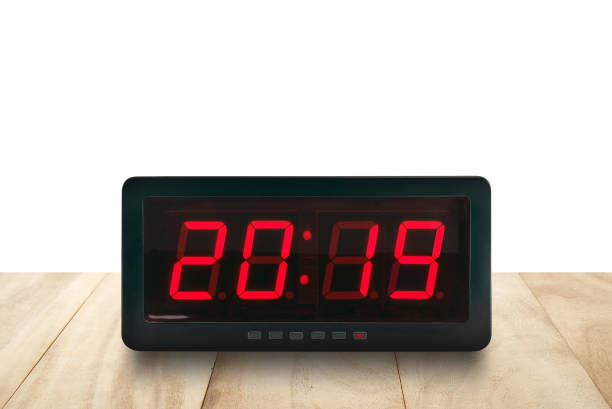 istock red led light illumination numbers 2019 on black digital electric alarm clock face on brown wooden table isolated on white background 1136377183