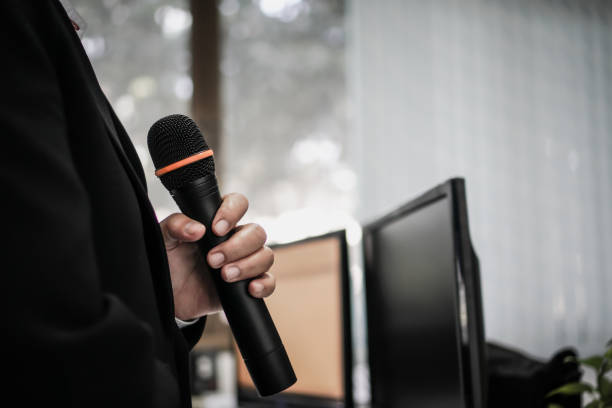 istock Speaker or businessman hold Microphone for speech or speaking in seminar Conference room, talking for lecture to audience university, Computer monitor desk Background. Business Presentation concept 1136377446