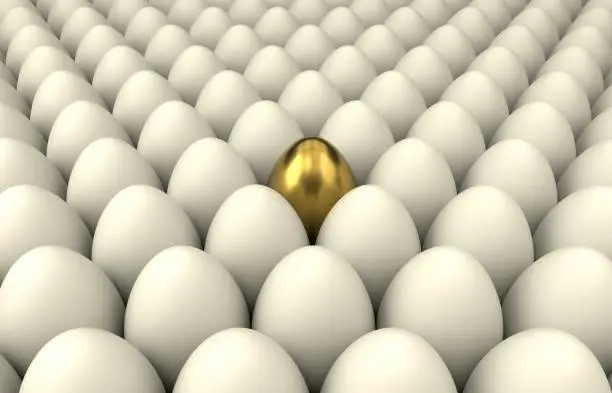 Photo of Close up of a golden egg among regular eggs
