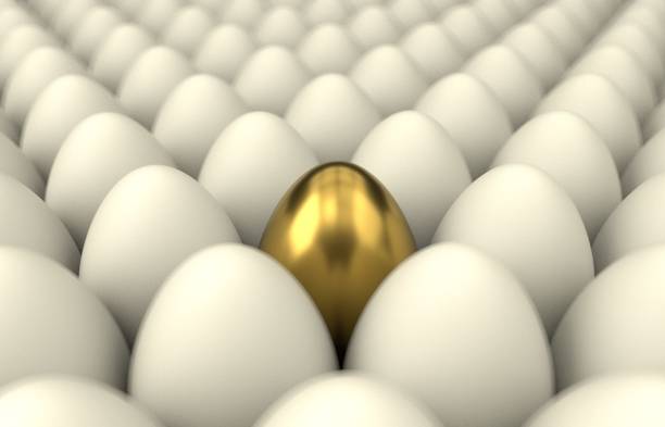 istock Close up of a golden egg among regular eggs, blur 1136379764