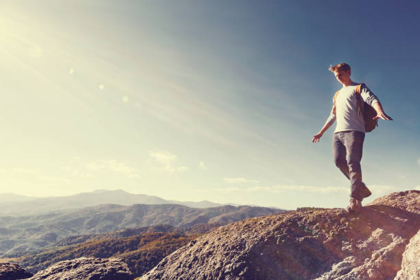 istock Man walking on the edge of a cliff 1136383309