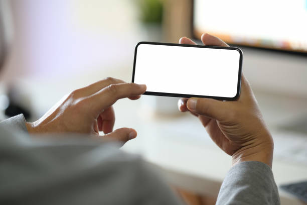 istock Man hands holding blank screen mobile smartphone in office 1136385095