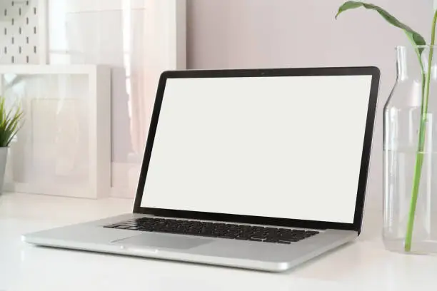 Photo of Mockup laptop on white wood workspace.