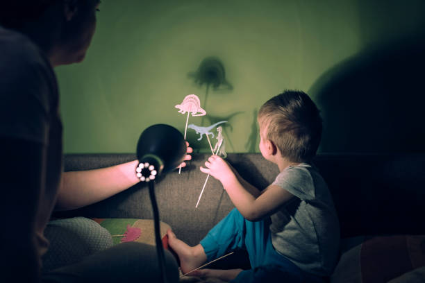 istock Mother and cute son playing with shadows 1136385746