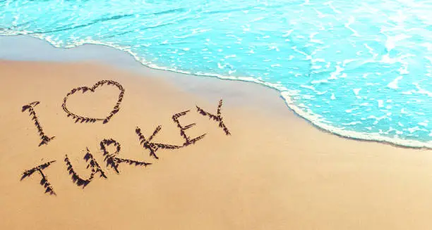 Photo of Turkey holidays concept. The inscription on the sand by the sea - I love Turkey