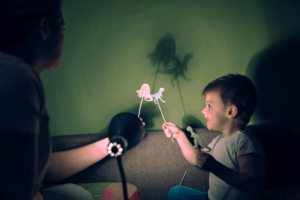 istock Mother and cute son playing with shadows 1136386956
