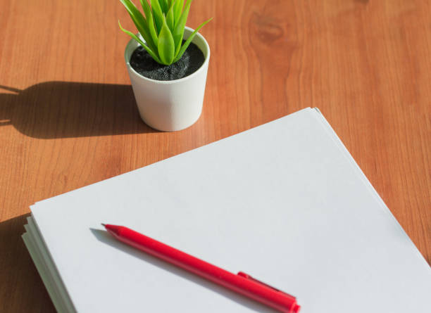 istock a stack of white paper and a pen on the office desktop 1136387282