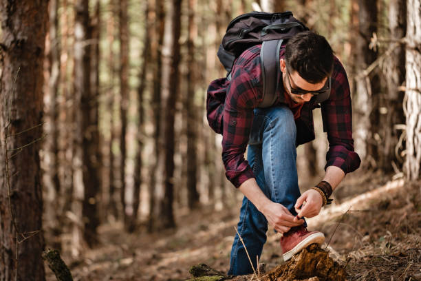 istock Man tying shoelace in the forest. 1136387584