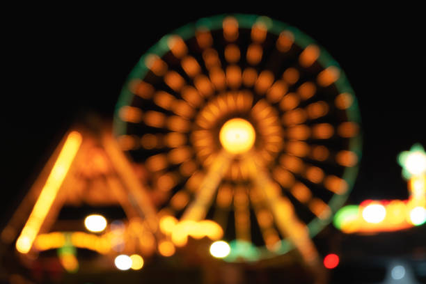 foto borrada noite com bokeh. - ferris wheel wheel blurred motion amusement park - fotografias e filmes do acervo