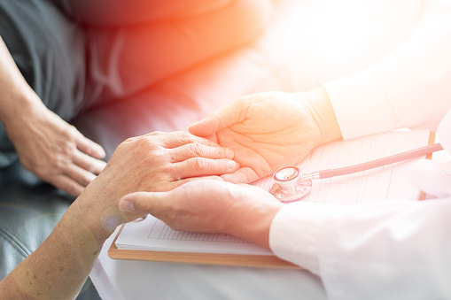 Paciente anciano de Parkinson y Alzheimer en edad avanzada con cuidador en cuidados paliativos. Vieja mujer sosteniendo la mano con el doctor médico. photo
