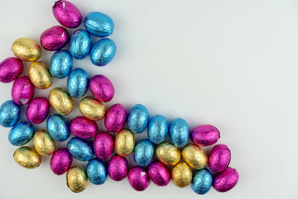istock Group of chocolate easter eggs in blue, yellow and pink paper 1136388802