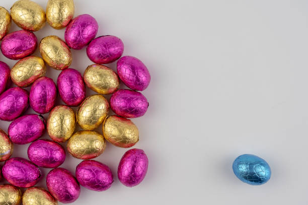istock Group of chocolate easter eggs in blue, yellow and pink paper 1136388841