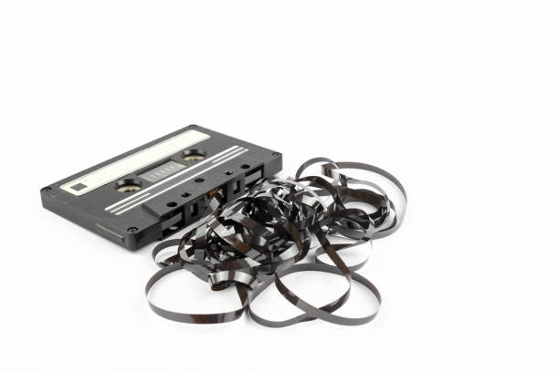 Useless Cassette tape with tape coming out This shows a well known problem with the old fashioned compact cassettes: the tape used to come out, making the cassette useless vintage portable silver radio stock pictures, royalty-free photos & images