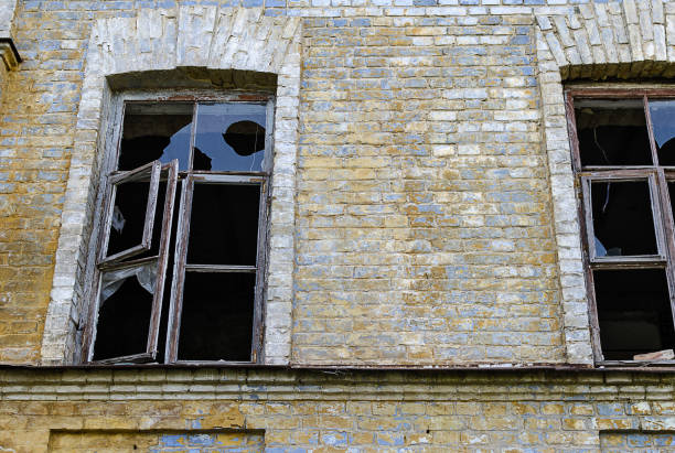 istock Windows with broken glasses in a old brick house 1136391802