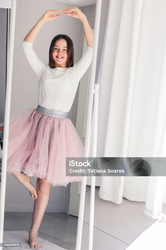 Pretty happy tween girl dancing like ballerina looking at mirror at home. Childhood dreams. Females Stock Photo