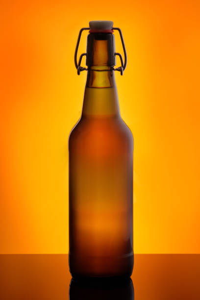 istock Brown beer bootle with swing top in orange back lit close-up 1136398821