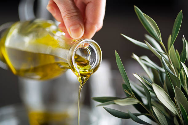 бутылка оливкового масла - cooking oil oil pouring olive oil стоковые фото и изображения