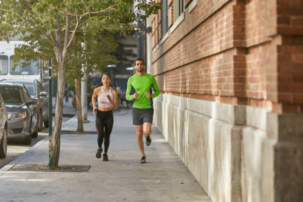 istock Friends jogging together on sidewalk in city 1136404222