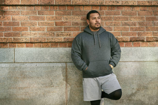 istock Thoughtful male athlete leaning on brick wall 1136405276