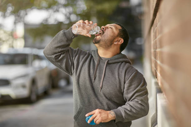 istock Tired male athlete drinking water after workout 1136405692