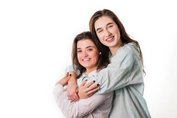 istock Two brunettes smile and embrace studio portrait 1136405917