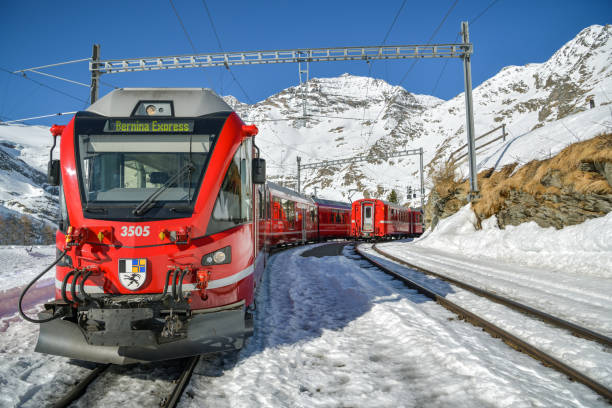 Alp Grum, Switzerland - February 16, 2019: Bernina Express train on Alp Grum stop just after the Bernina Pass waiting during short break for passengers