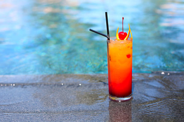 istock Glass with a bright tequila sunrise cocktail by the pool. 1136406500