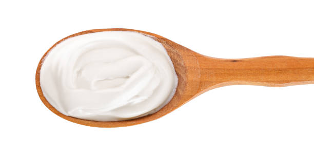 istock Sour cream in wooden spoon isolated on white background. Top view. Flat lay 1136408355