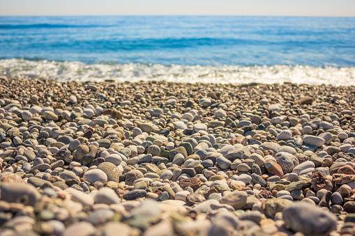 Mediterranean landscape in Antalya, Turkey. Blue sea, waves and pebble beach