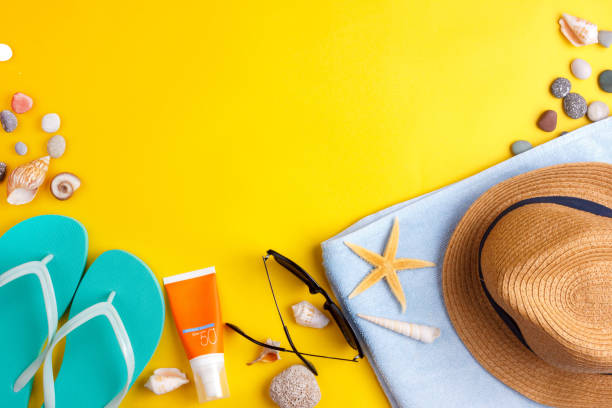 Sun glasses, sun screen, headphones, smartphone, towel, slippers. Flatlay beach vacation on a yellow background. Sun glasses, sun screen, headphones, smartphone, towel, slippers Flatlay beach vacation on yellow background straw hat photos stock pictures, royalty-free photos & images