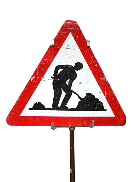 Dilapidated road works sign of man digging, attached to pole stock photo