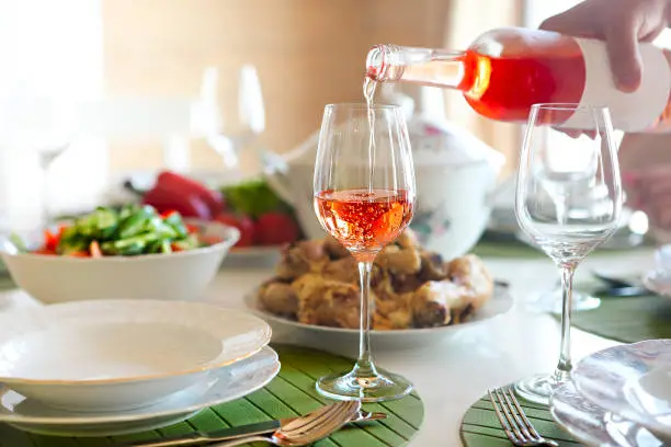 Photo of Table with rose wine, fish soup, salad and chiken