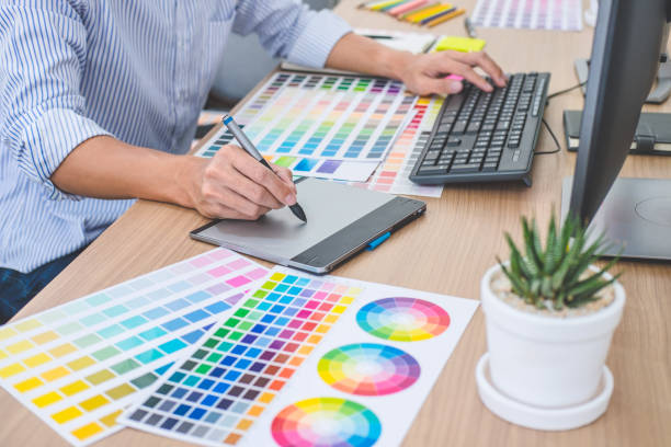 istock Image of male creative graphic designer working on color selection and drawing on graphics tablet at workplace with work tools and accessories in workspace 1136413010