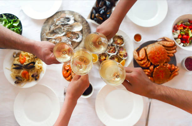 marisco de jantar fino dos povos e vinho branco na tabela - caranguejo marisco - fotografias e filmes do acervo