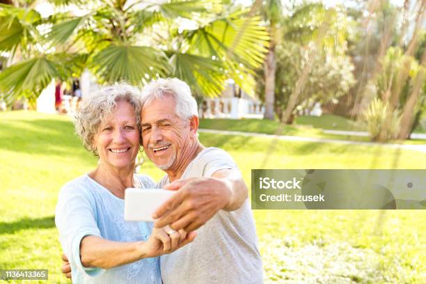 Happy Senior Couple Taking Selfie On Mobile Phone Stock Photo - Download Image Now - 60-64 Years, 70-79 Years, Couple - Relationship