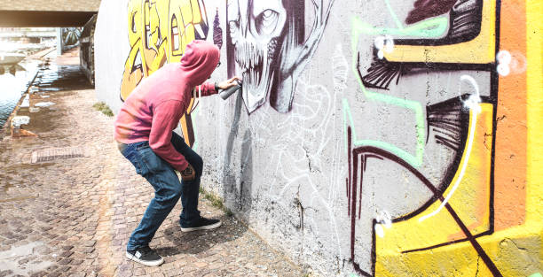 artista callejero pintando graffiti colorido en la pared pública-concepto de arte moderno con el chico urbano realizando y preparando murales en vivo con aerosol multi color aerosol-brillante retro vintage filter - graffiti men wall street art fotografías e imágenes de stock