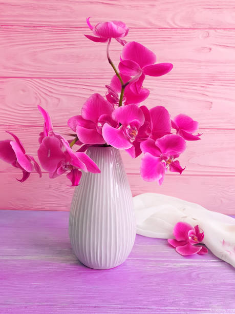 istock vase orchid flower on wooden background 1136413754