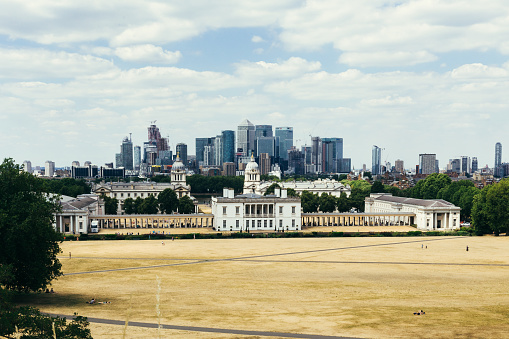 London, UK - July 23, 2018: An expansive view of London as seen from Greenwich Park and the observatory. This viewpoint has proven to be very popular with visitors; as it is always crowded and full of tourists.