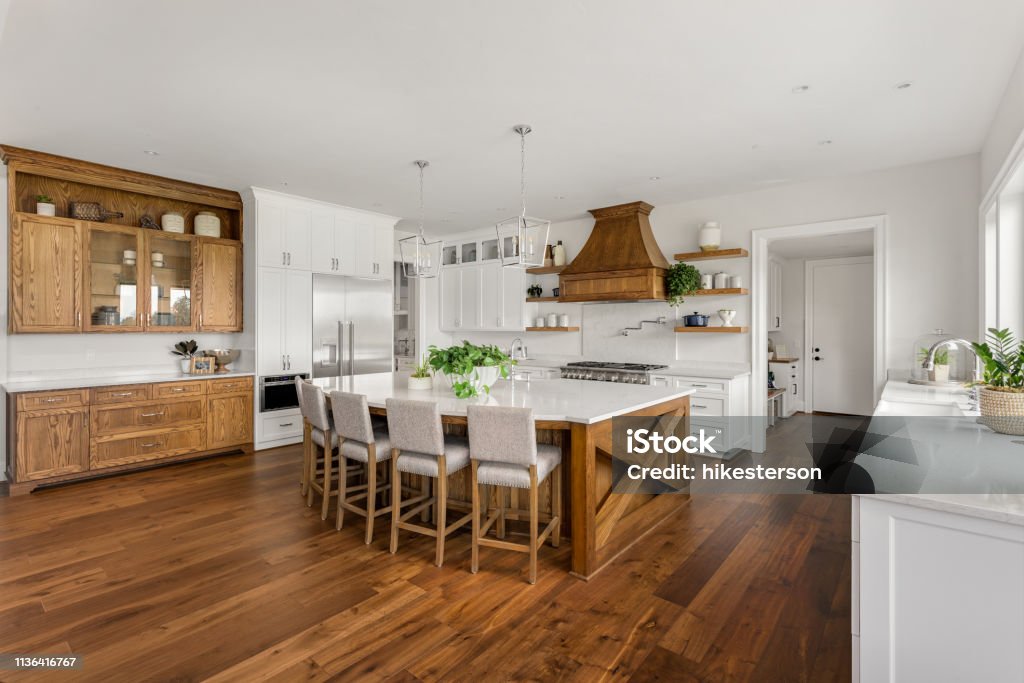 beautiful kitchen in new luxury home with island, pendant lights, and hardwood floors. kitchen in newly constructed luxury home Kitchen Stock Photo